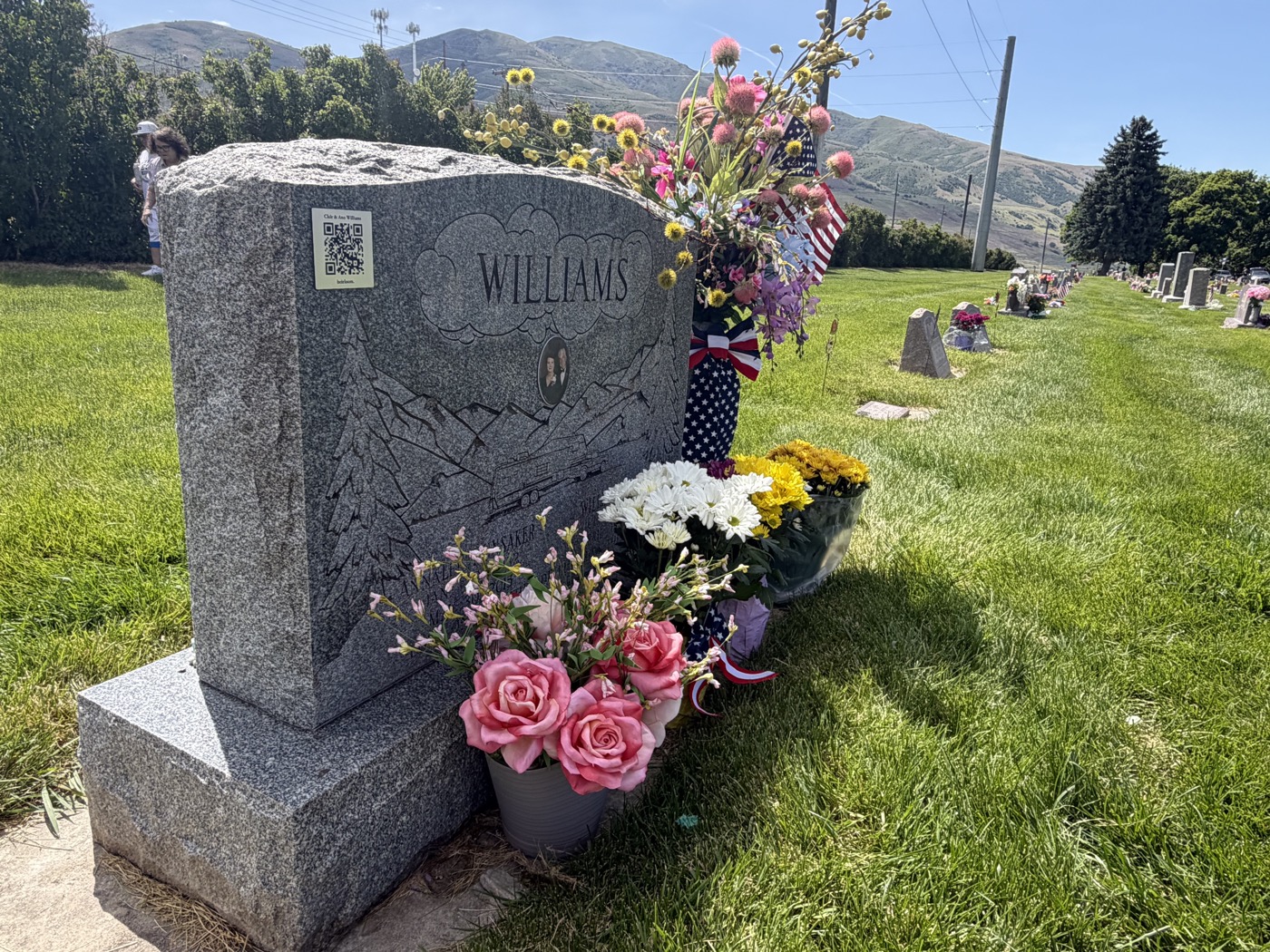 An Heirloom QR plaque mounted on a granite headstone.